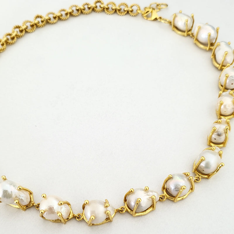 Gold necklace with pearls on a white background